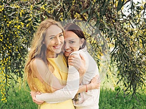 Young beautiful smiling women in spring Australian Golden wattle trees.