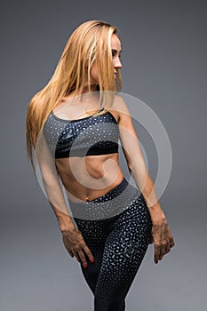 Young beautiful sport woman move on dark background