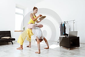 Young beautiful sportive couple training partner yoga asanas at home.