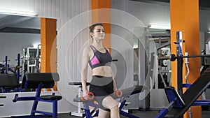 Young beautiful sporty girl doing lunge with dumbbells in gym. 60 fps