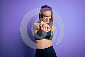 Young beautiful sporty girl doing sport wearing sportswear over isolated purple background Beckoning come here gesture with hand