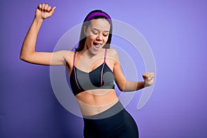 Young beautiful sporty girl doing sport wearing sportswear over isolated purple background Dancing happy and cheerful, smiling
