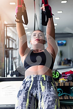 Young beautiful sporty woman is doing exercises in a fitness room. Gym workout