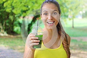 Young beautiful sporty woman drinking green detox smoothie. Fitness girl drinking vegetable smoothie after fitness running workout