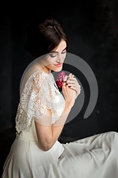 Young beautiful stylish woman, bride, spring trend, flowers, hairstyle, beauty make-up, white dress, dark background