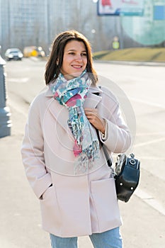young beautiful stylish woman walking down the street in pink coat, autumn fashion trend, smiling, happy