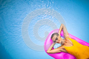 Young Beautiful Suntanned Woman relaxing next to a Swimming Pool