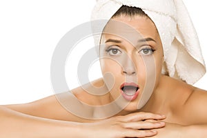 Young beautiful surprised woman with towel on her head