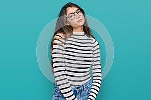 Young beautiful teen girl wearing casual clothes and glasses relaxed with serious expression on face