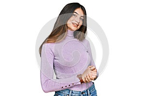 Young beautiful teen girl wearing turtleneck sweater with hands together and crossed fingers smiling relaxed and cheerful