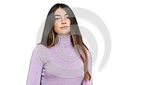 Young beautiful teen girl wearing turtleneck sweater relaxed with serious expression on face