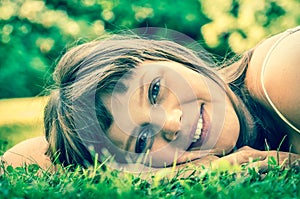 Young beautiful teenage girl lying on the green grass