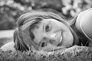 Young beautiful teenage girl lying on the green grass