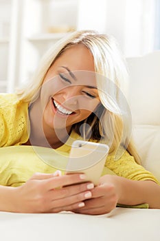 Young and beautiful teenage girl typing sms using a smartphone