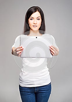 Young and beautiful teenager girl holding an ipad tablet pc in h
