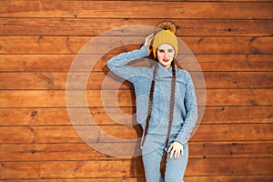 Young beautiful teenager girl posing on a wooden wall background