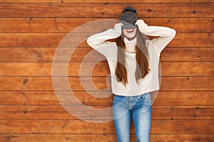 Young beautiful teenager girl posing on a wooden wall background