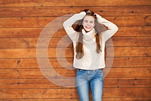 Young beautiful teenager girl posing on a wooden wall background