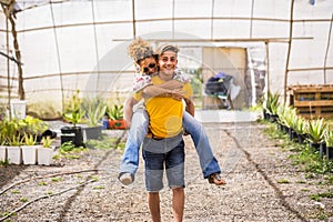 Young beautiful teenager play with his mother middle age pretty woman carrying her to his back. couple mother son having fun