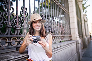 Young beautiful tourist woman using a photo camera