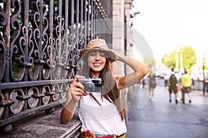 Young beautiful tourist woman using a photo camera