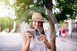 Young beautiful tourist woman using a photo camera
