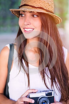 Young beautiful tourist woman using a photo camera