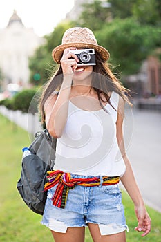 Young beautiful tourist woman using a photo camera