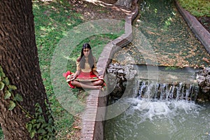 Young beautiful traditional indian woman practicing yoga in nature