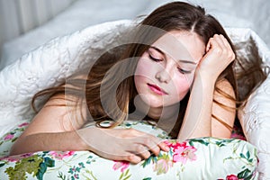 Young beautiful white woman awaking in light room.