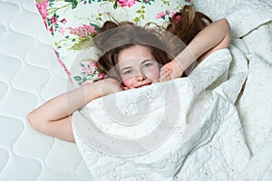 Young beautiful white woman awaking in light room.