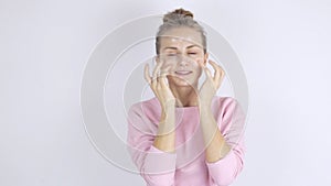 Young beautiful woman applying cream on her face. Skincare concept