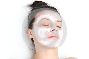 Young beautiful woman applying facial mask. Skin care, beauty treatments. Spa treatments and care of the cats in the beauty salo