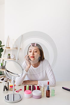 Young beautiful woman applying her make-up