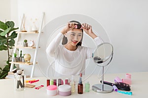 Young beautiful woman applying her make-up