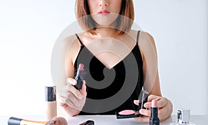 Young beautiful woman applying make up