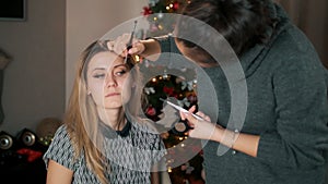 Young beautiful woman applying make-up by asian make-up artist