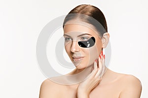 Young beautiful woman applying a mask for the face of the therapeutic black mud. Spa treatment