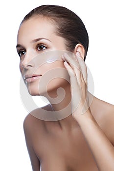 Young beautiful woman applying moisturize cream photo