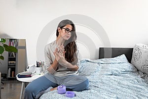 Young beautiful woman applying moisturize cream on her hands. Self care girl morning routine with skin care product for soft