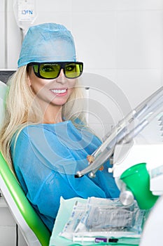 Young beautiful woman with beautiful white teeth sitting on a dental chair.