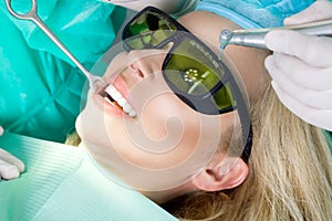 Young beautiful woman with beautiful white teeth sitting on a dental chair.