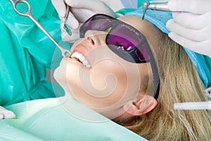 Young beautiful woman with beautiful white teeth sitting on a dental chair.