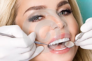 Young beautiful woman with beautiful white teeth sitting on a dental chair.