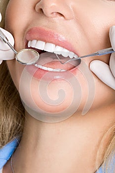 Young beautiful woman with beautiful white teeth sitting on a dental chair.