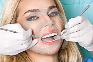 Young beautiful woman with beautiful white teeth sitting on a dental chair.