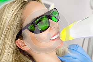 Young beautiful woman with beautiful white teeth sitting on a dental chair.