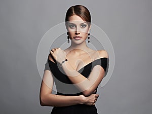 Young beautiful woman.Beauty girl in black dress and jewelry