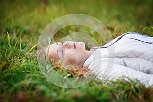 Young beautiful woman. Beauty girl lying on grass, closed eyes