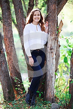 Young beautiful woman. Beauty smiling teenager girl in autumn park